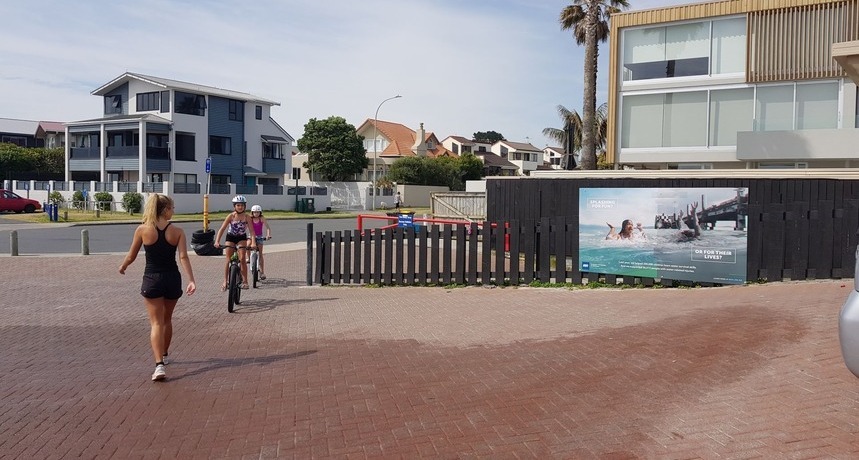 People walking past advertising sign at surf club